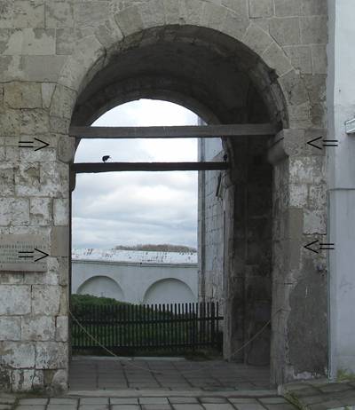 Arch under the northern passage. The traces of turnings at the places of the gate hinges are marked by arrows.